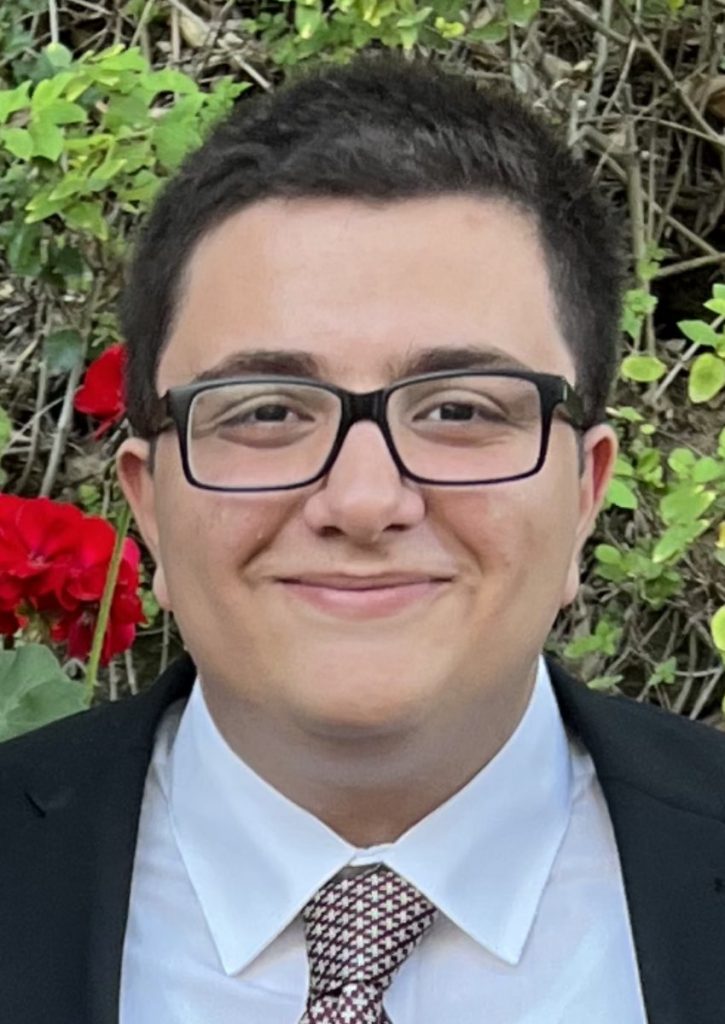 Shayan wearing a suit at his sister's wedding in a garden.