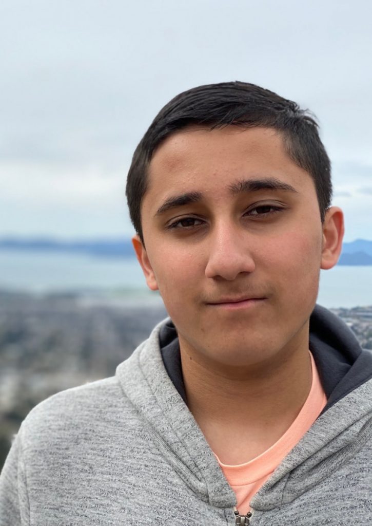 Vedant smiling in front of a city skyline